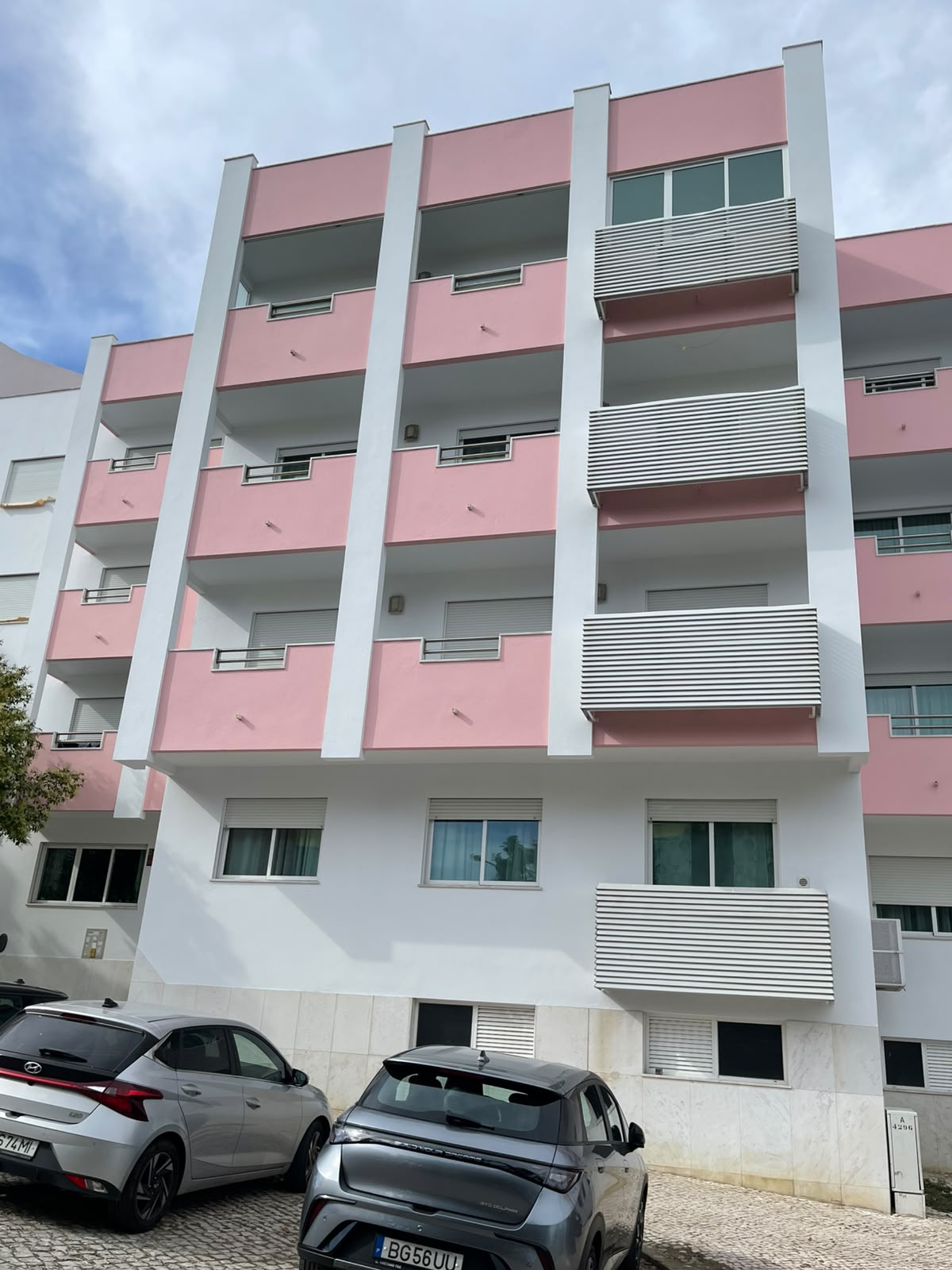Fachada de condomínio renovada em tons rosa e branco