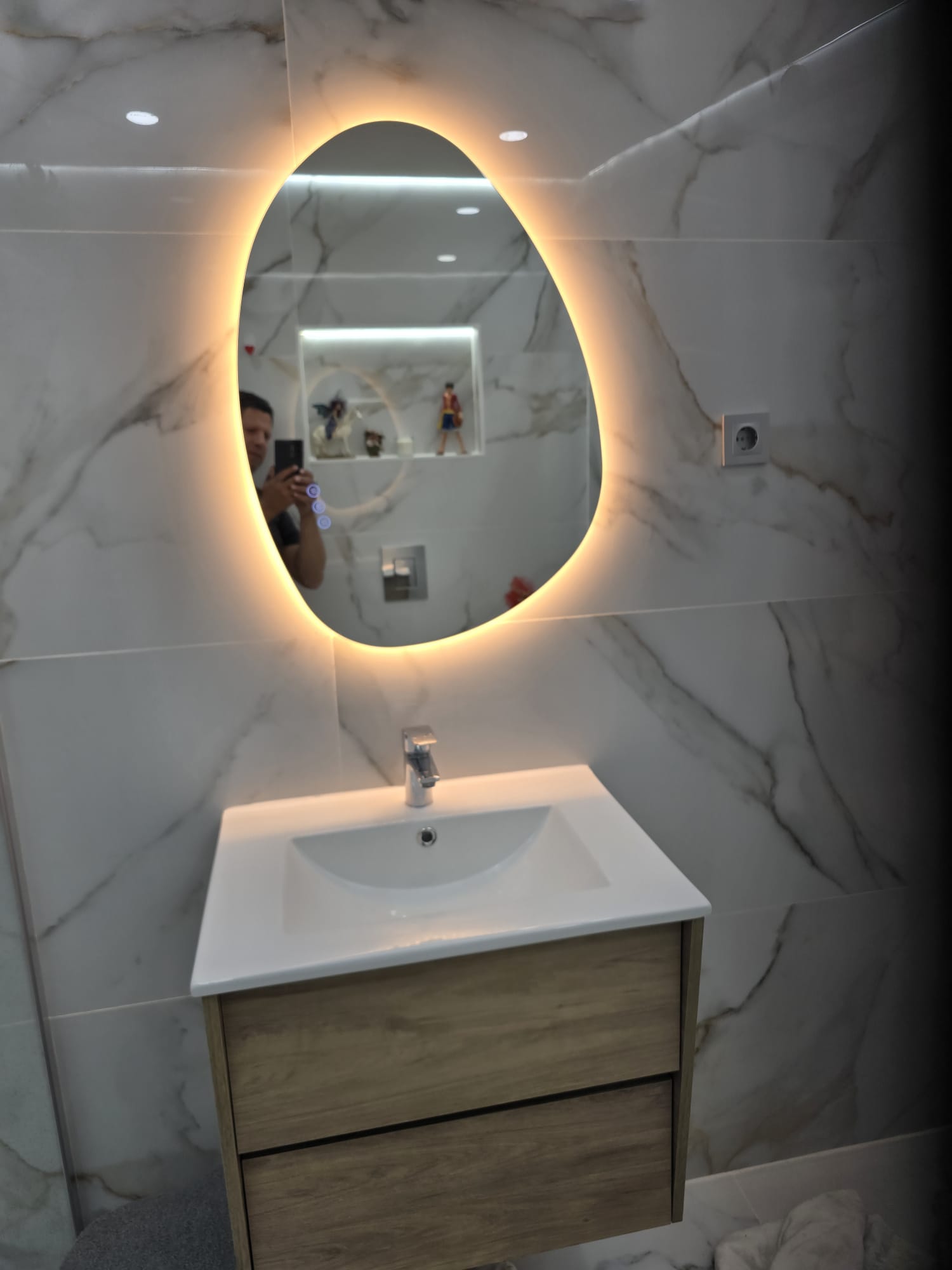 Casa de banho remodelada com móvel suspenso e espelho iluminado
